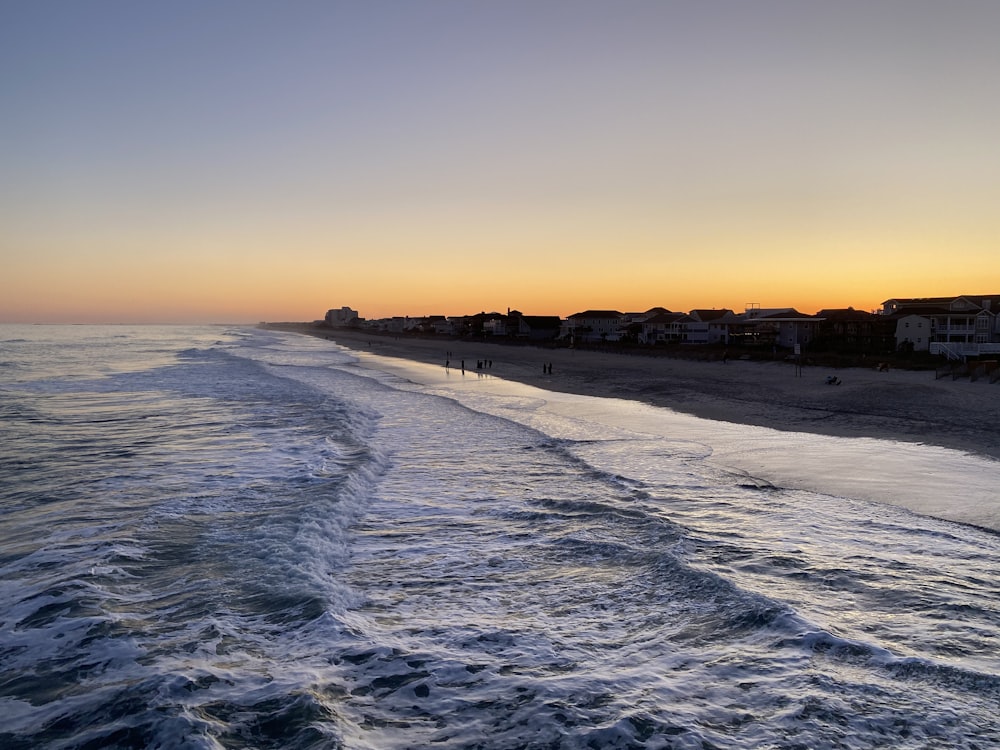 sea waves crashing on shore during sunset