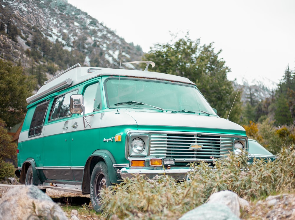 green and white volkswagen t-2 on rocky ground during daytime