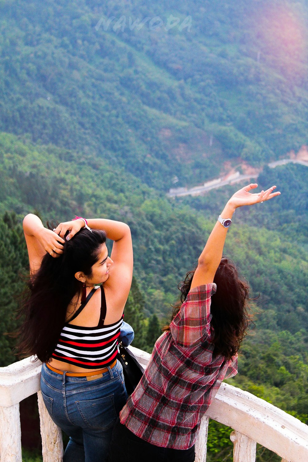 woman in black and white stripe tank top raising her hands