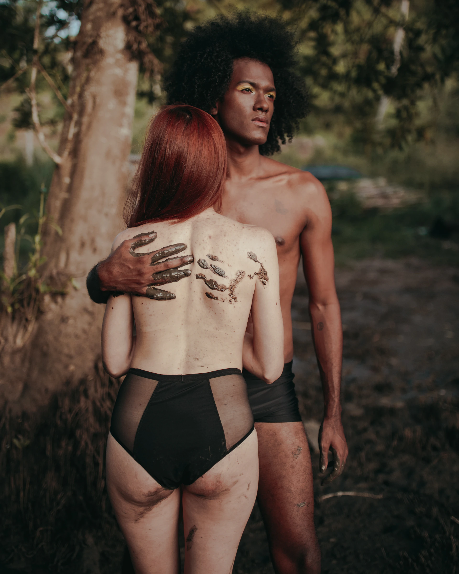 topless woman in black panty standing on brown grass field during daytime