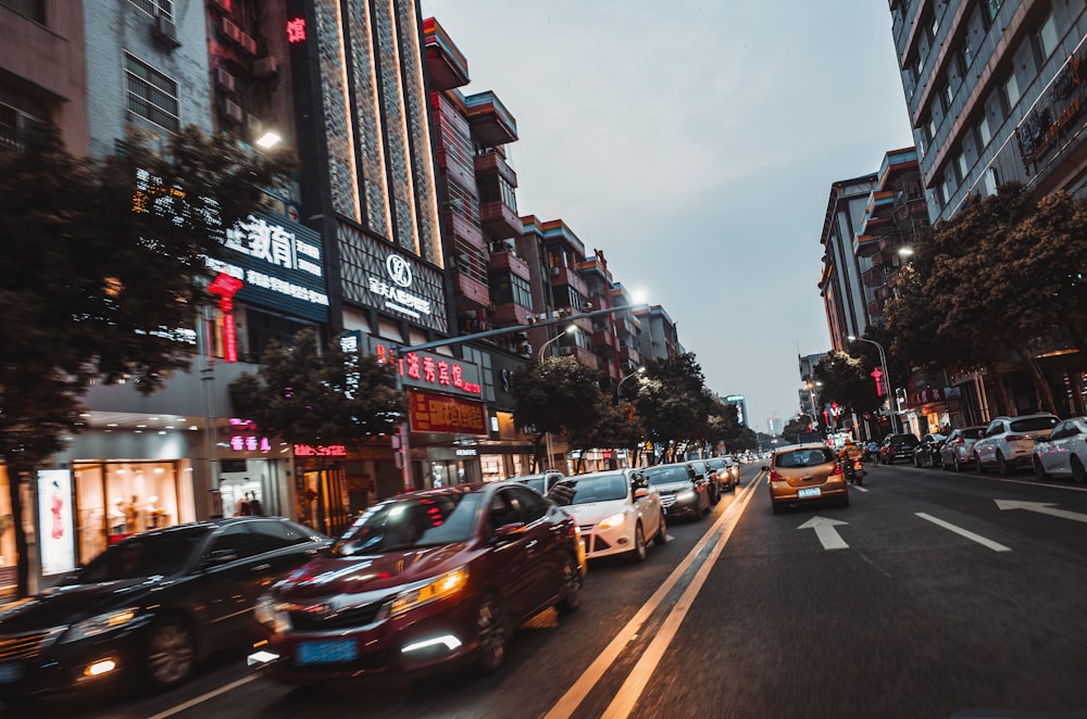 cars on road in between high rise buildings during daytime