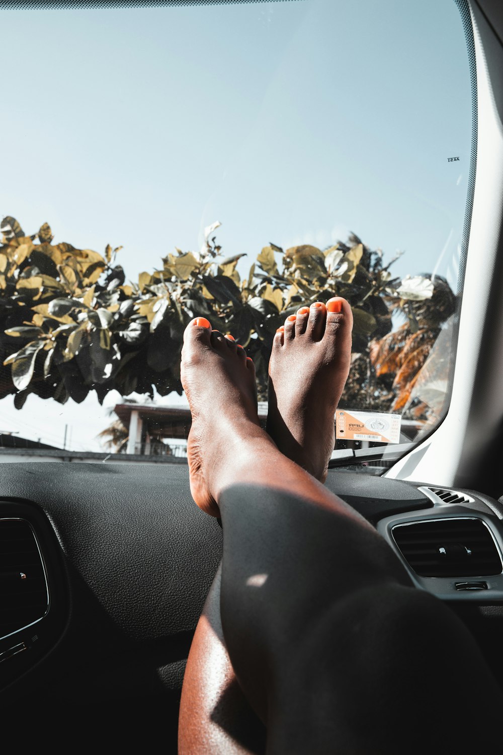 persons feet on car dashboard