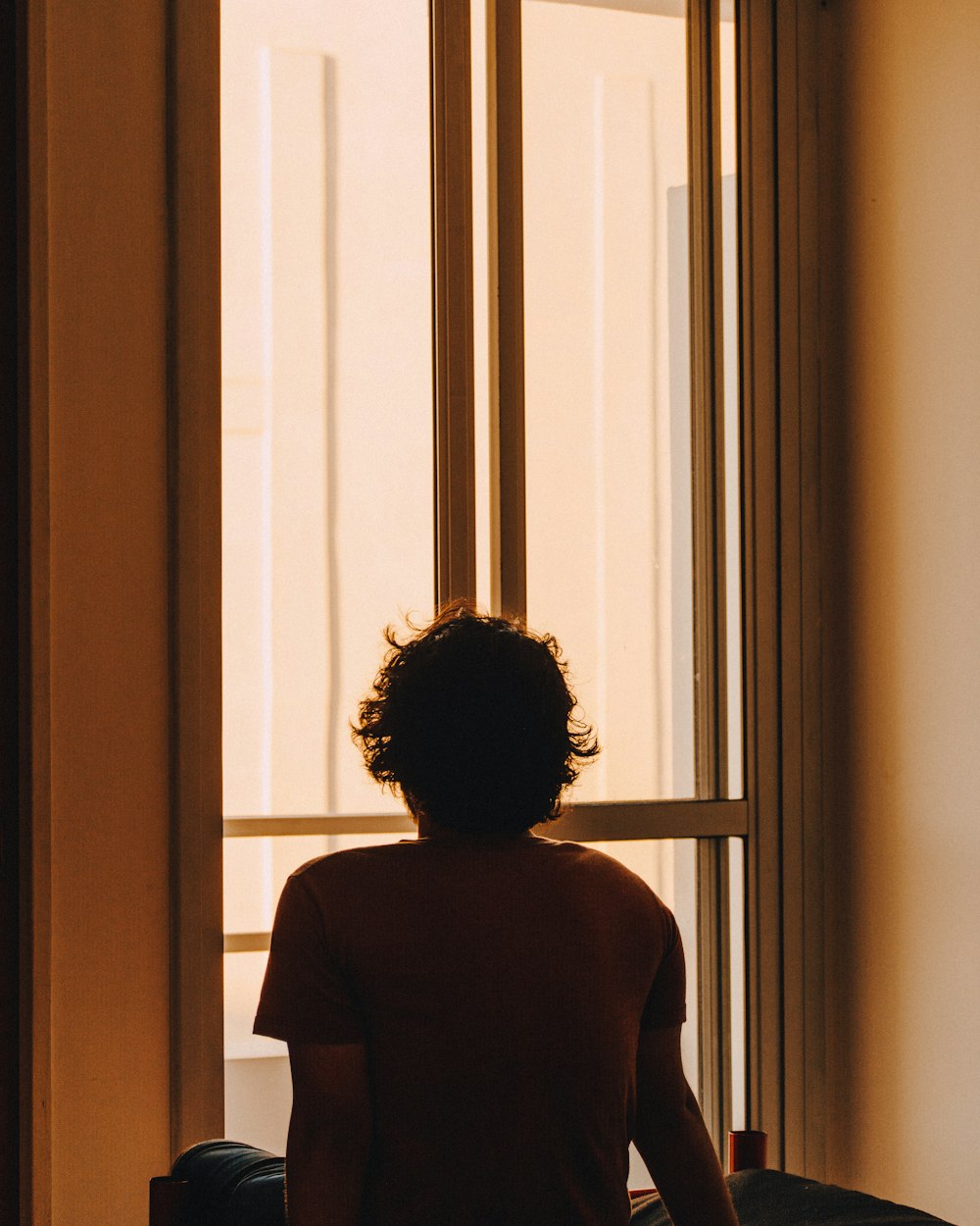 woman in black shirt standing near window