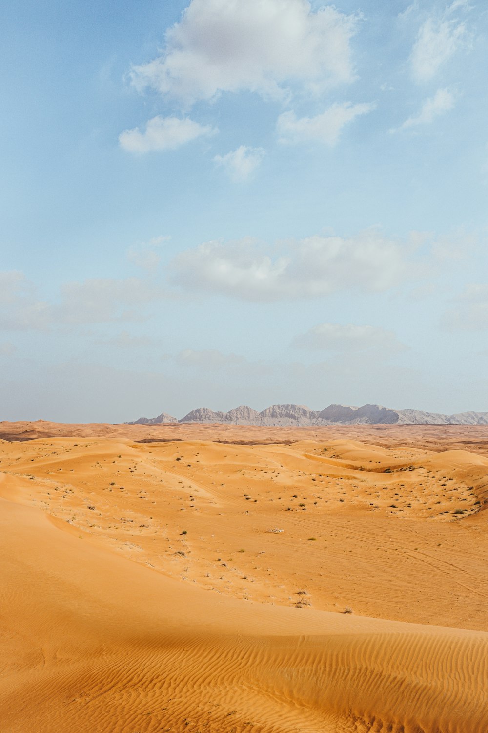 brown sand under white clouds during daytime