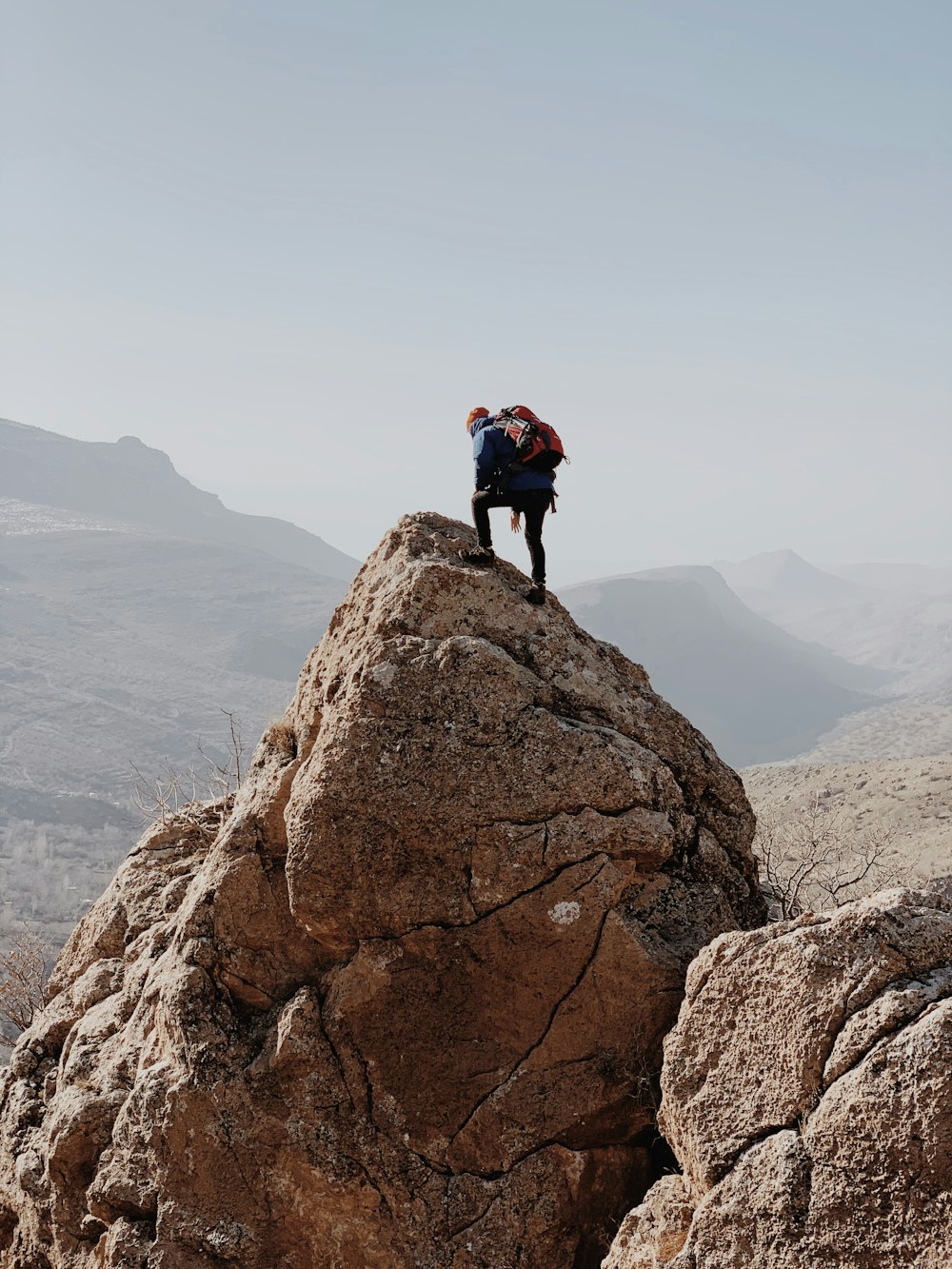 a man standing on top of a large rock