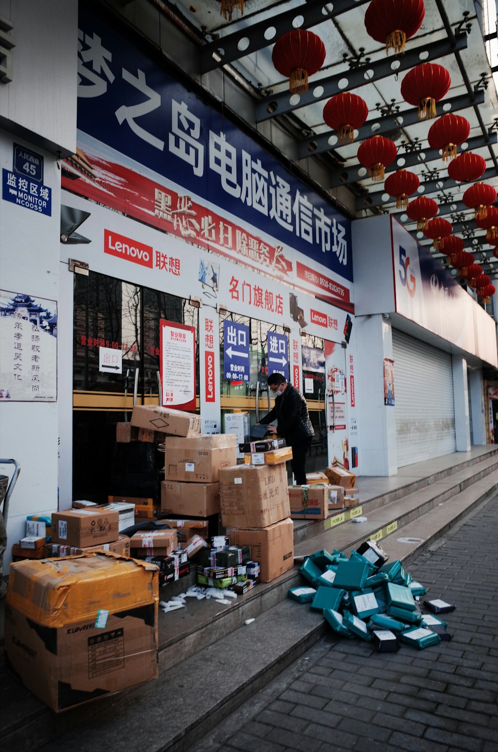 woman in black shirt and brown pants standing in front of brown cardboard boxes