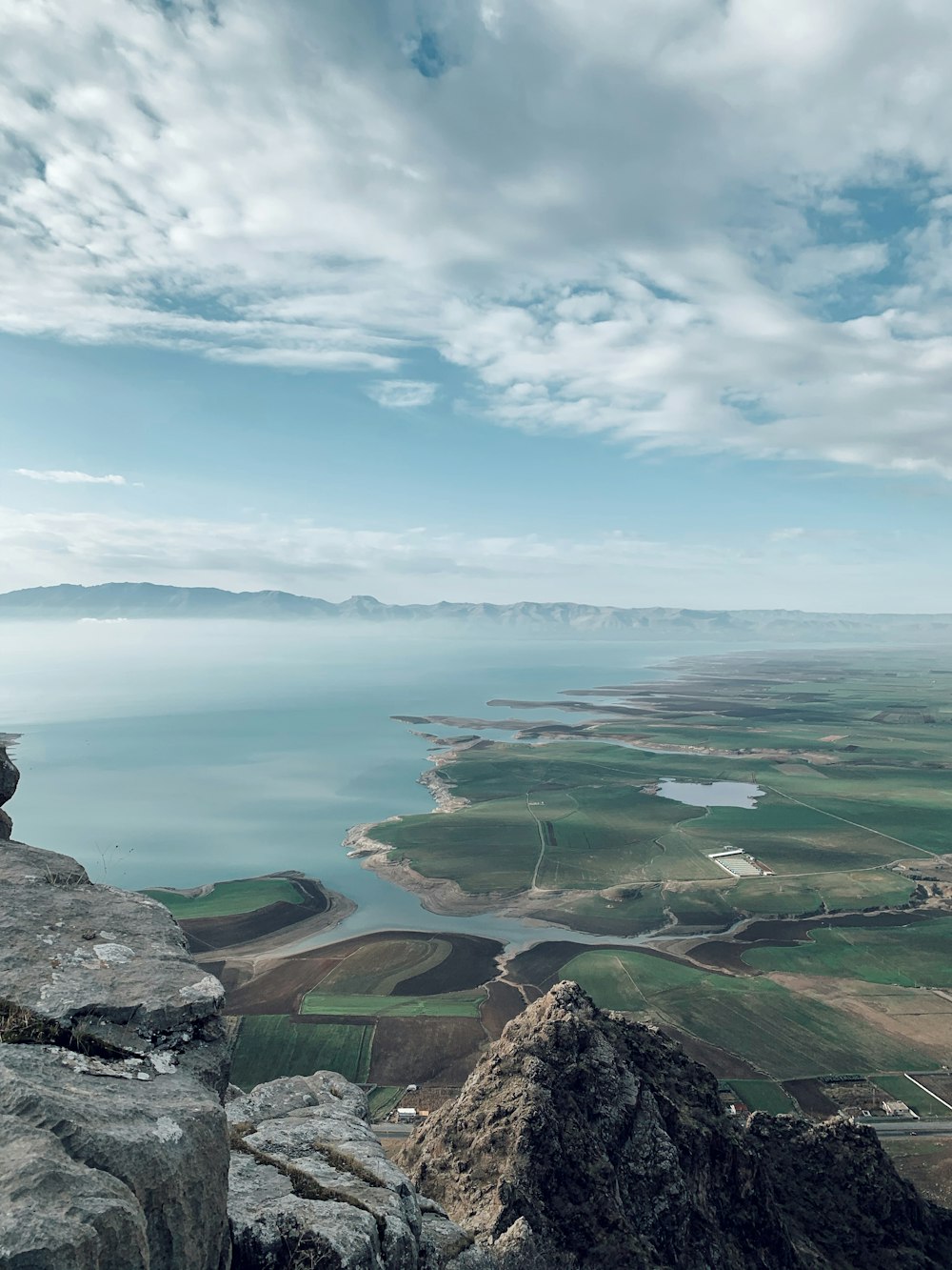 a person sitting on top of a cliff overlooking a large body of water