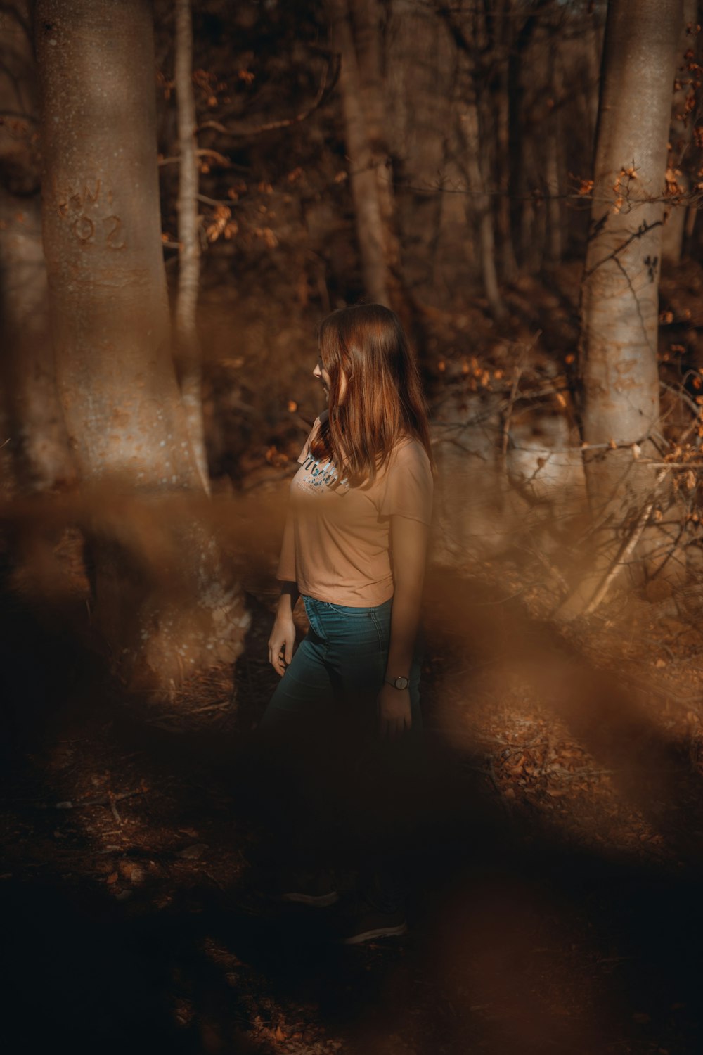 woman in white t-shirt and black pants standing in forest