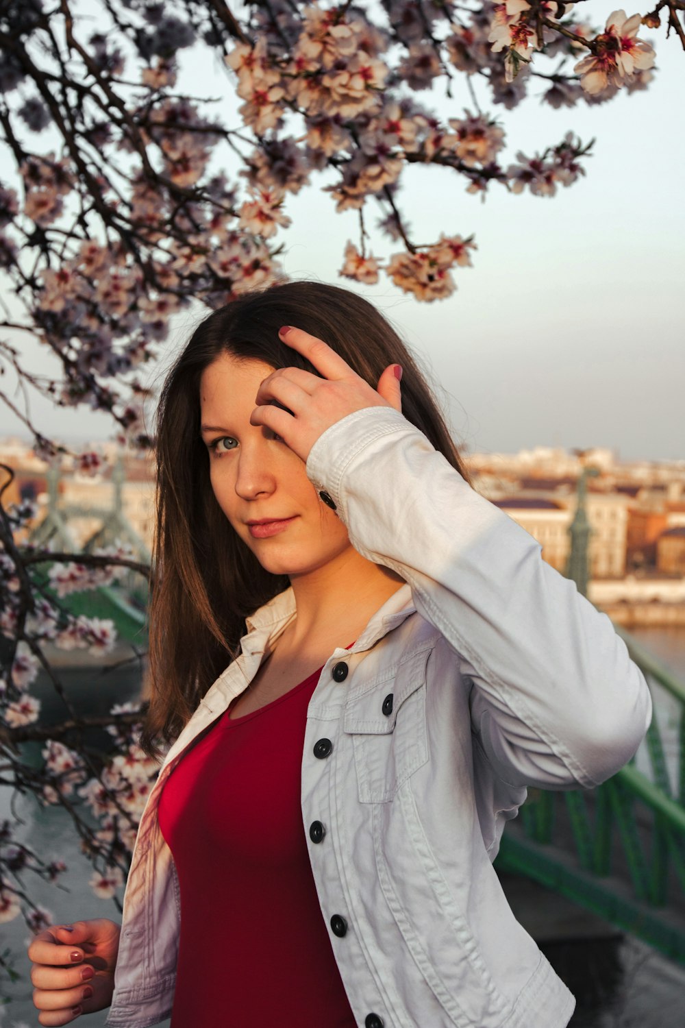 woman in white jacket covering her face with her hair