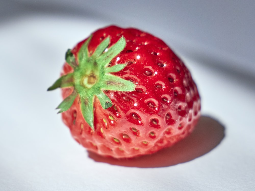 red strawberry on white textile