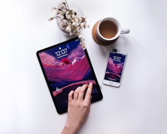 person holding black android smartphone beside white ceramic mug