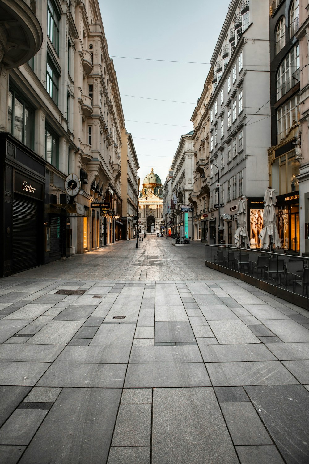 昼間、建物と建物の間の歩道を歩く人々
