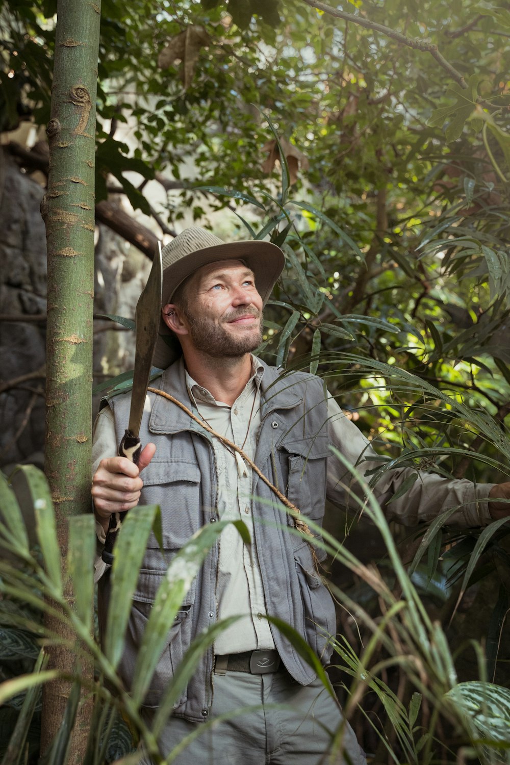 man in gray button up shirt holding green bamboo stick