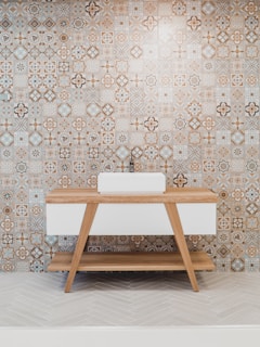 brown wooden table beside white and black wall