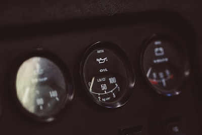 A close-up view of three circular gauges on a dashboard. The center gauge displays an oil pressure indicator with a needle pointing at 40 PSI, accompanied by text labels for oil and pressure units. The other gauges are slightly blurred, with the presence of numerical scales and indicators.