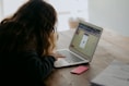 woman in black long sleeve shirt using macbook air