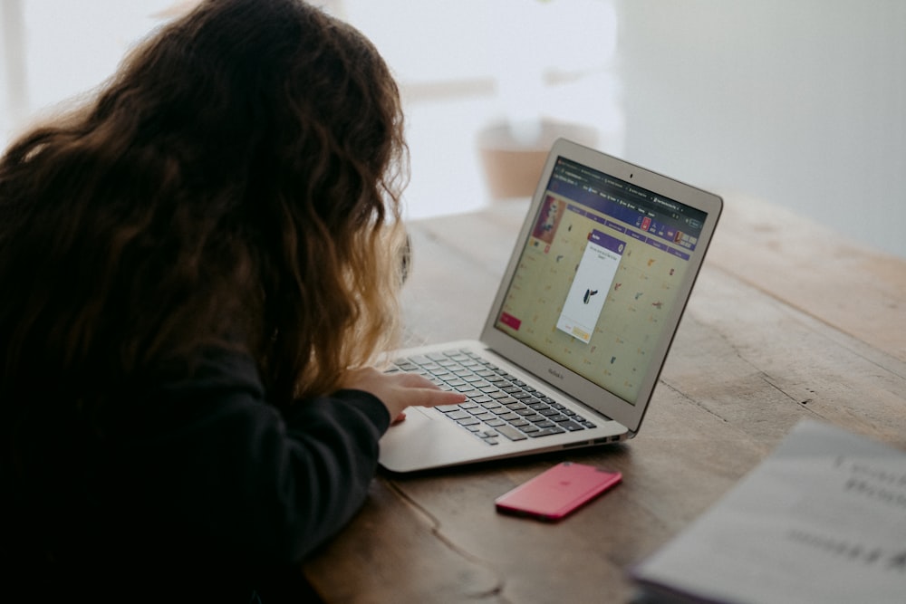 woman in black long sleeve shirt using macbook air