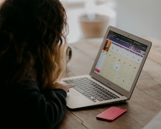 woman in black jacket using macbook air