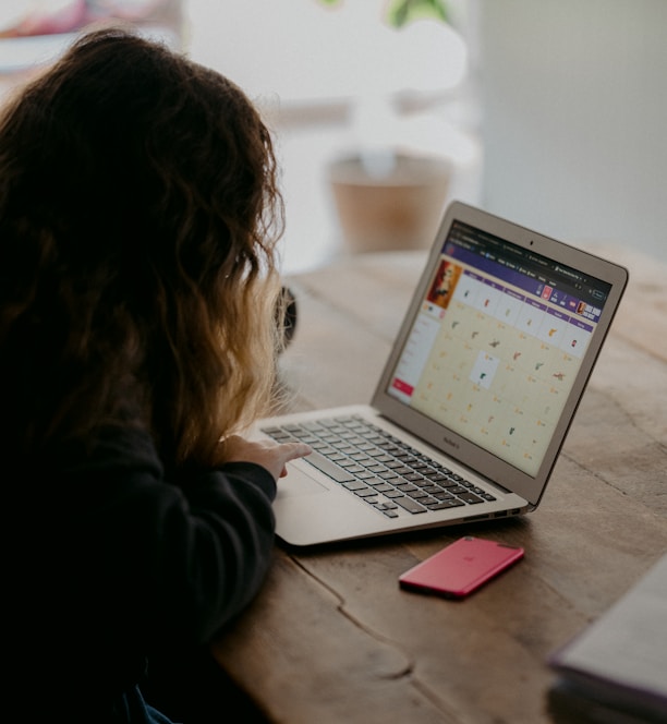 woman in black jacket using macbook air