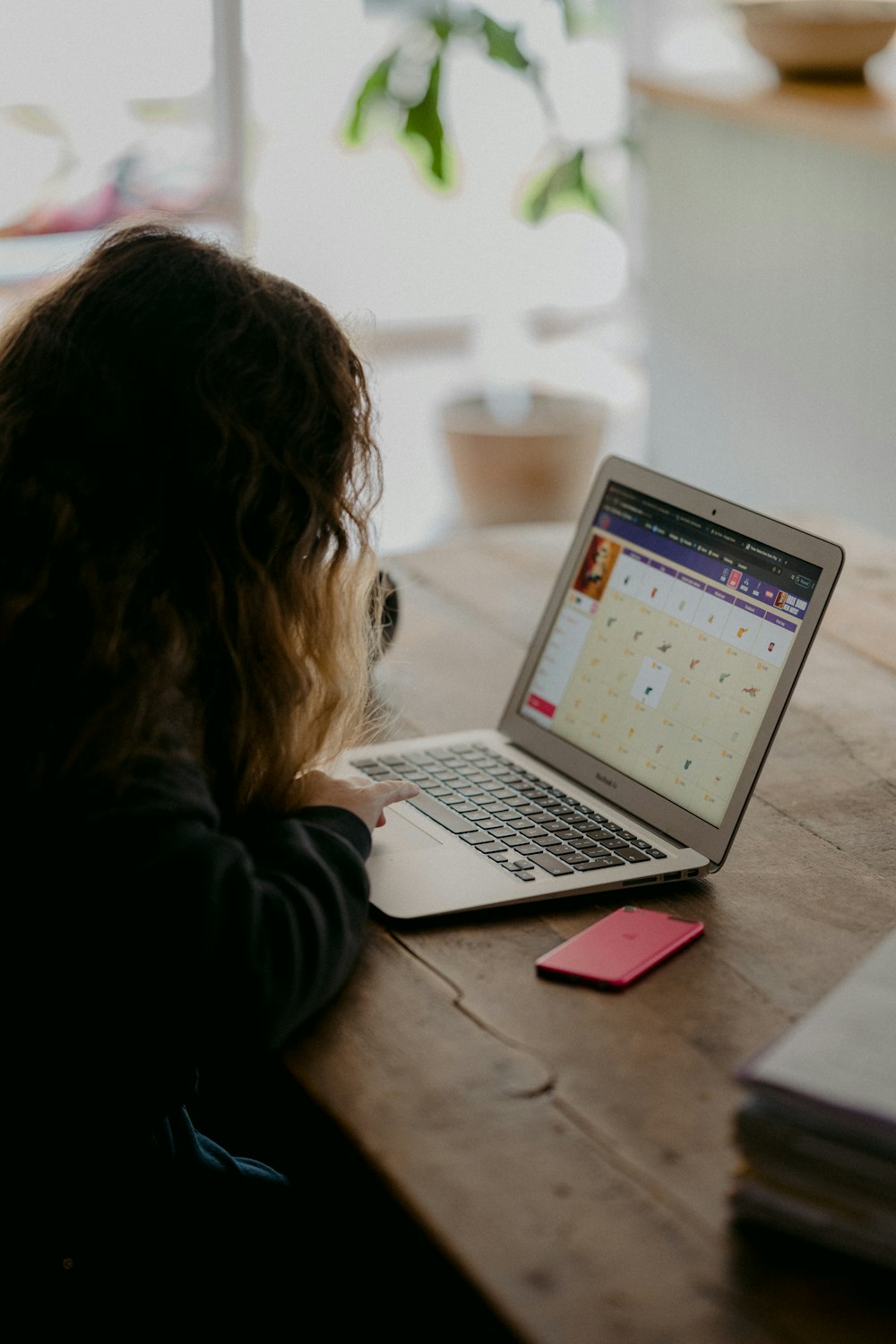 woman in black jacket using macbook air