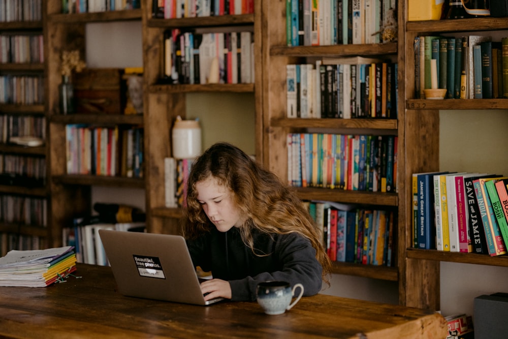 Frau im schwarzen Langarmhemd mit MacBook