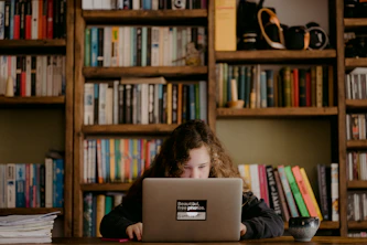 A student happily studying with digital psychology resources on a laptop in a cozy room.