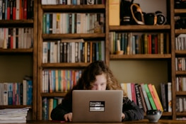 A focused student studying on a laptop in a cozy home environment.