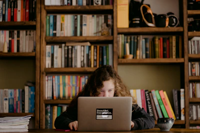 A student attentively watching an art tutorial video on a laptop in a cozy study space