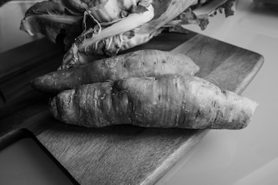 grayscale photo of raw fish on wooden table yam teams background