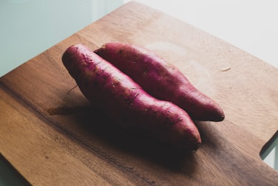 two red sausage on brown wooden chopping board yam teams background