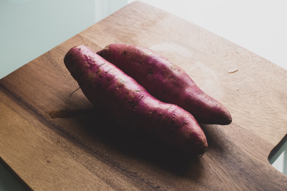 deux saucisses rouges sur une planche à découper en bois brun