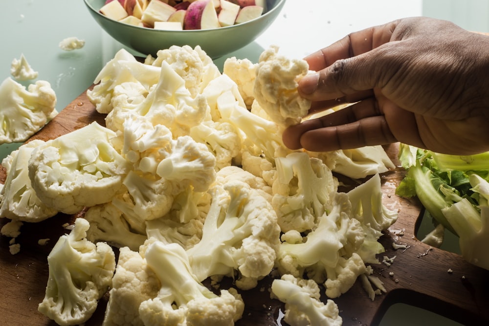 Person mit grüner und roter Keramikschale mit weißer Creme