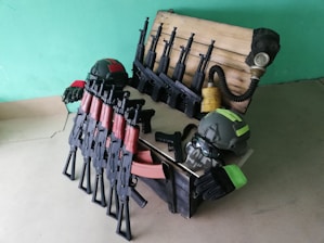 A close-up of airsoft replicas lined up on a tactical gear background.