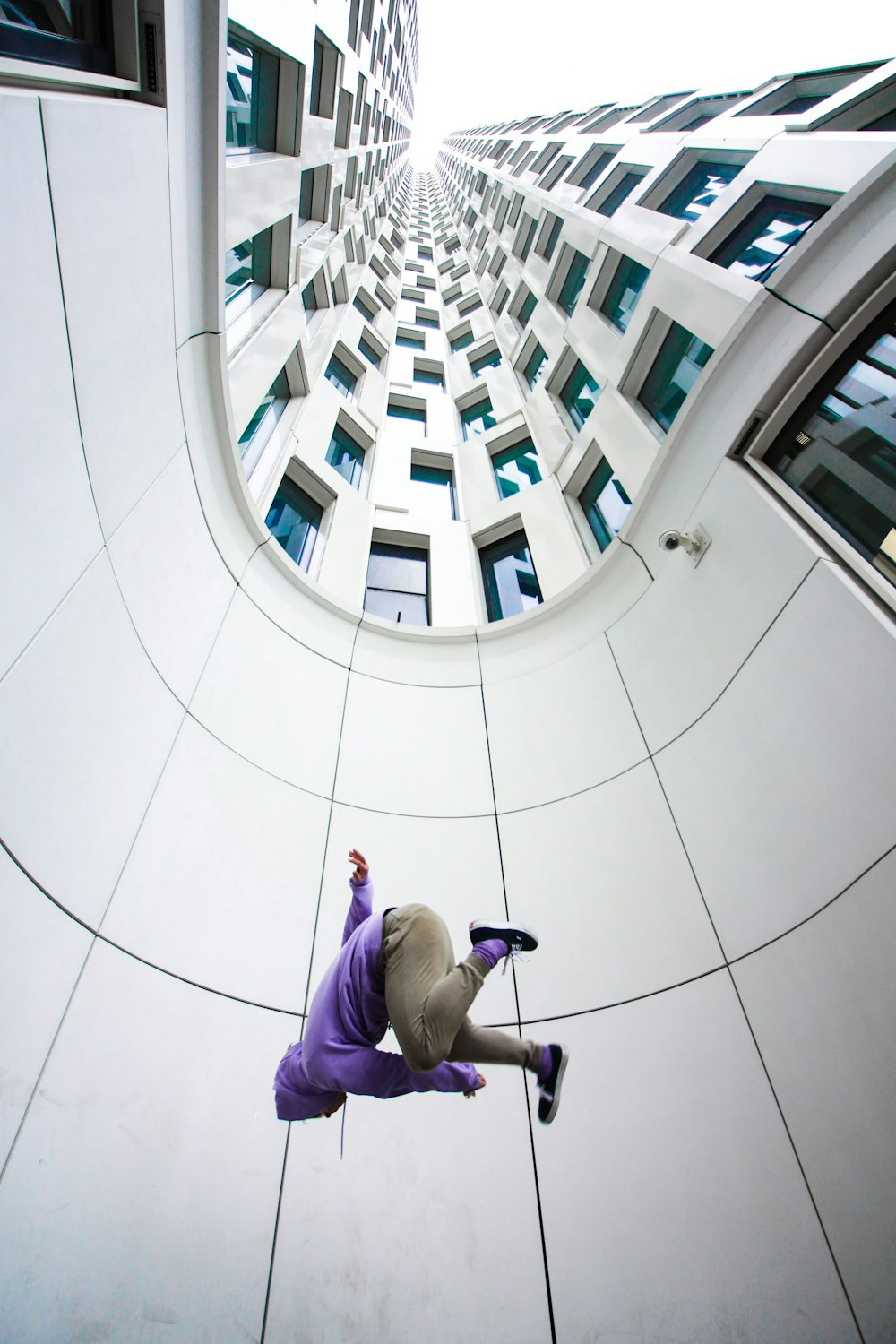 man in gray hoodie sitting on white floor tiles