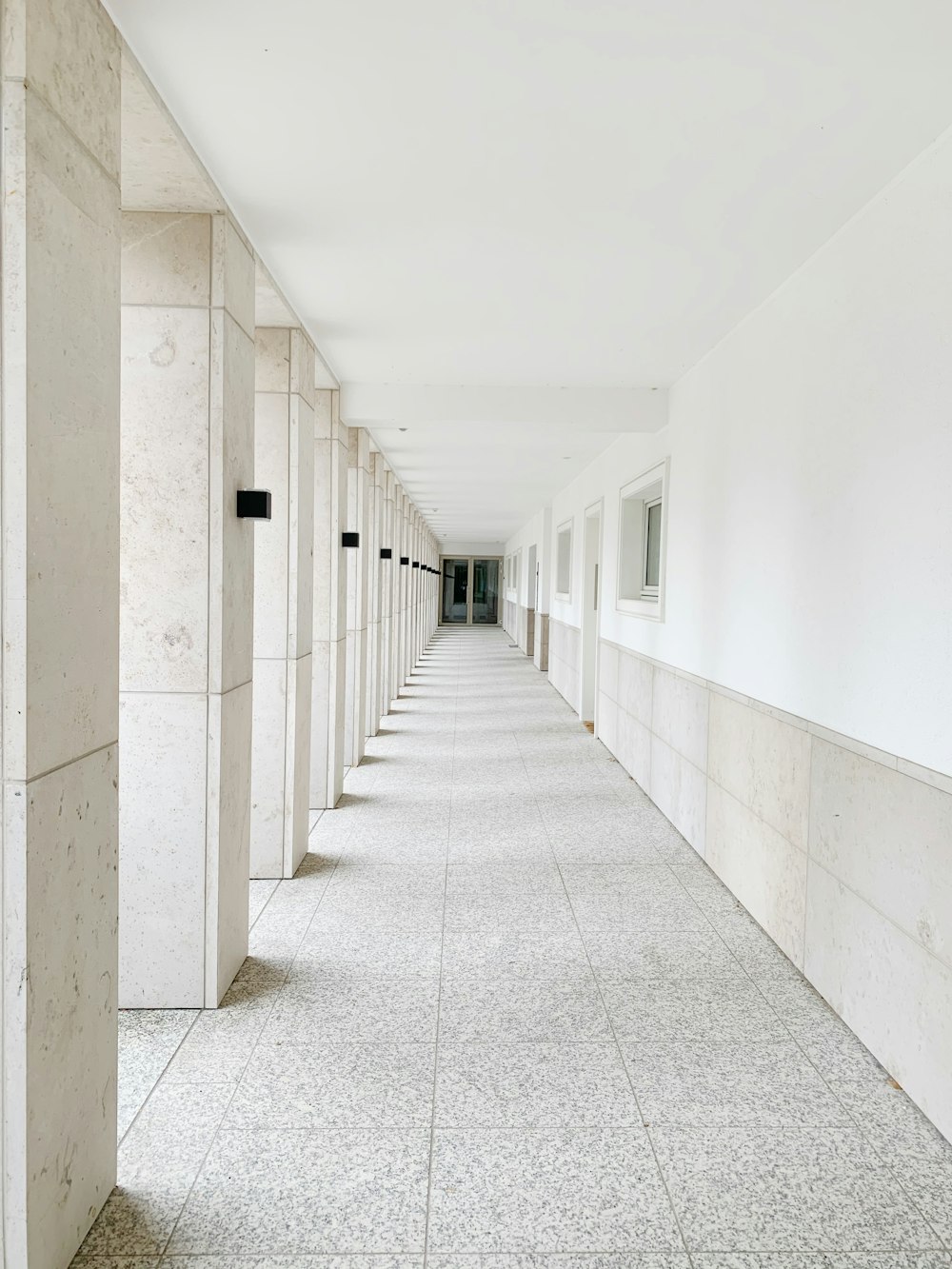 a long hallway lined with white walls and doors