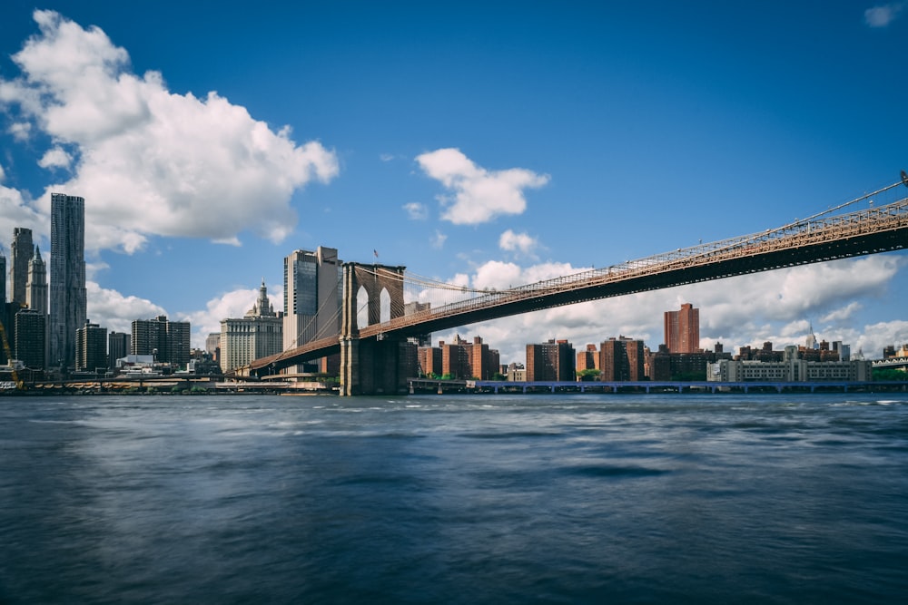 gray concrete bridge over water under blue sky during daytime