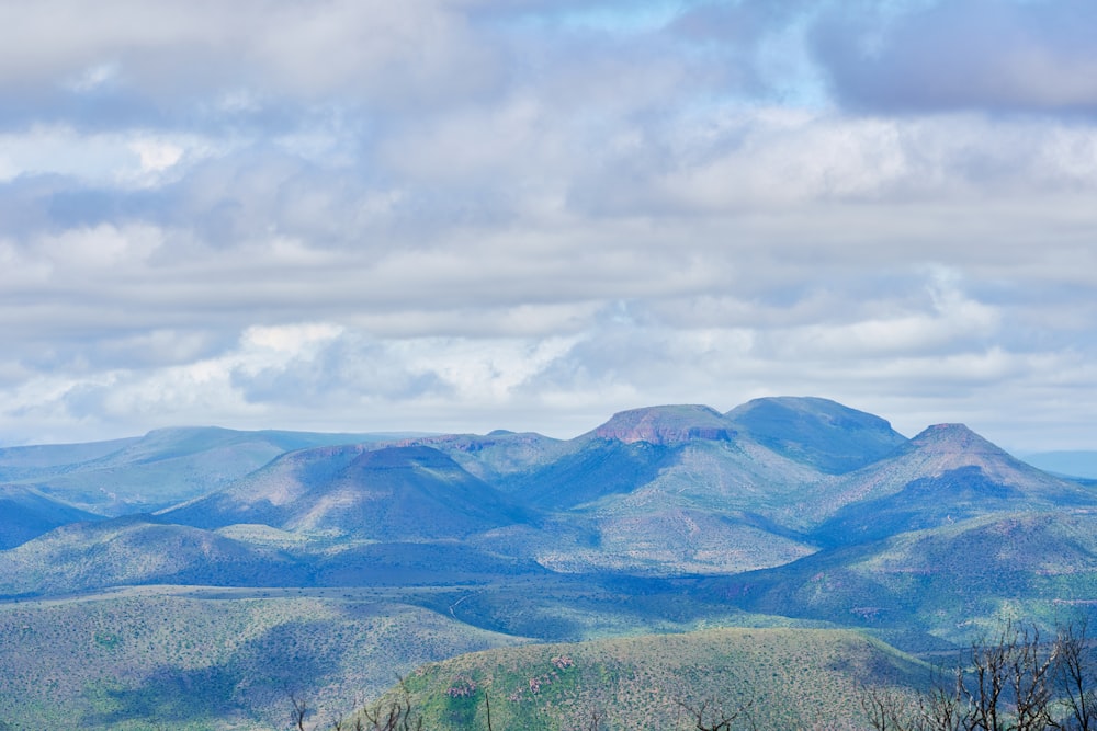 green and brown mountains under white clouds and blue sky during daytime