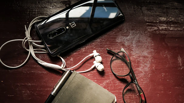 A vibrant flat lay of a tablet showing a language course interface surrounded by headphones and a notebook.