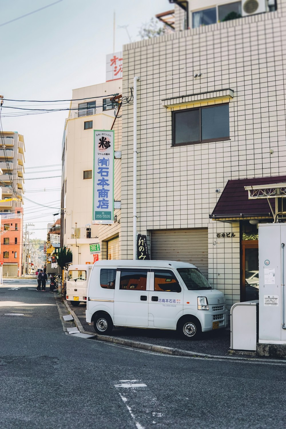 white van parked beside brown building during daytime