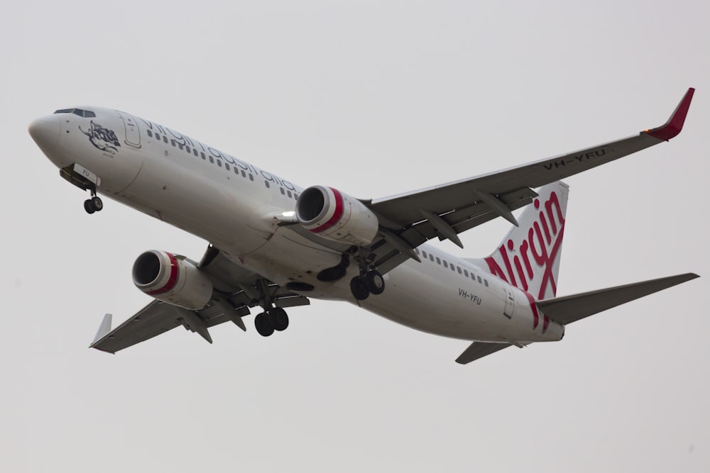 Avión blanco y rojo en el aire durante el día