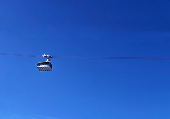 A sleek fiber optic cable installation against a clear blue sky over a small town.
