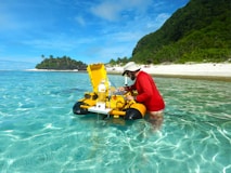 red shirt man adjusting a floating marine monitoring station