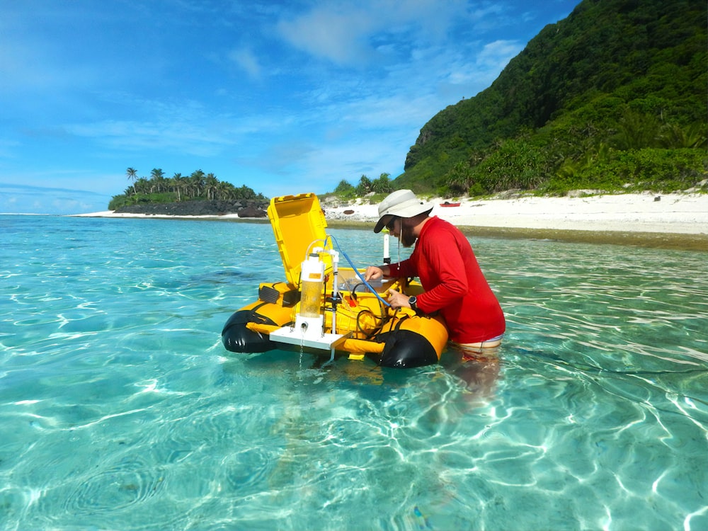 man in red shirt riding yellow kayak on sea during daytime