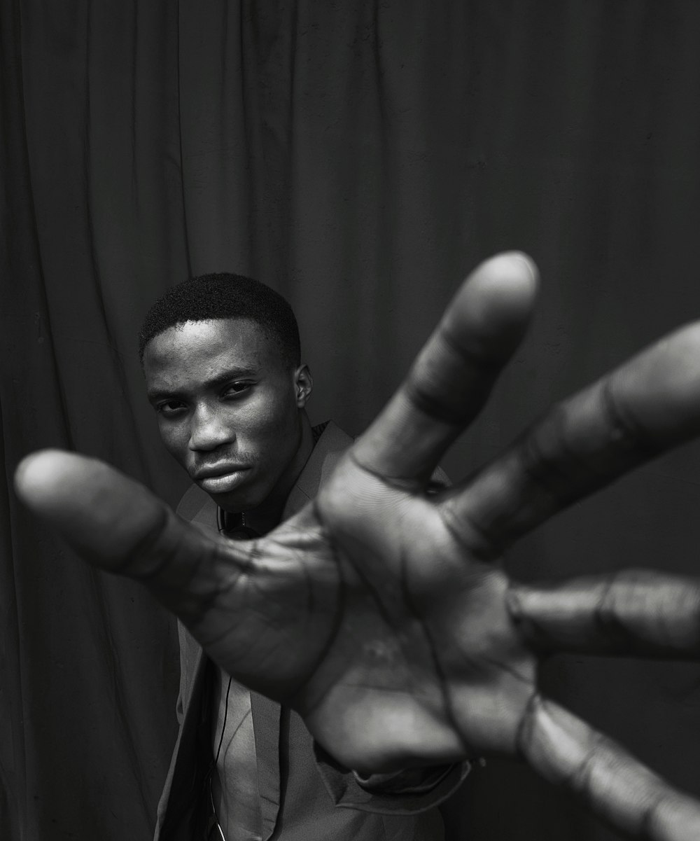 grayscale photo of man with tattoo on his right hand