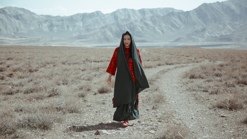 woman in black dress standing on brown field during daytime