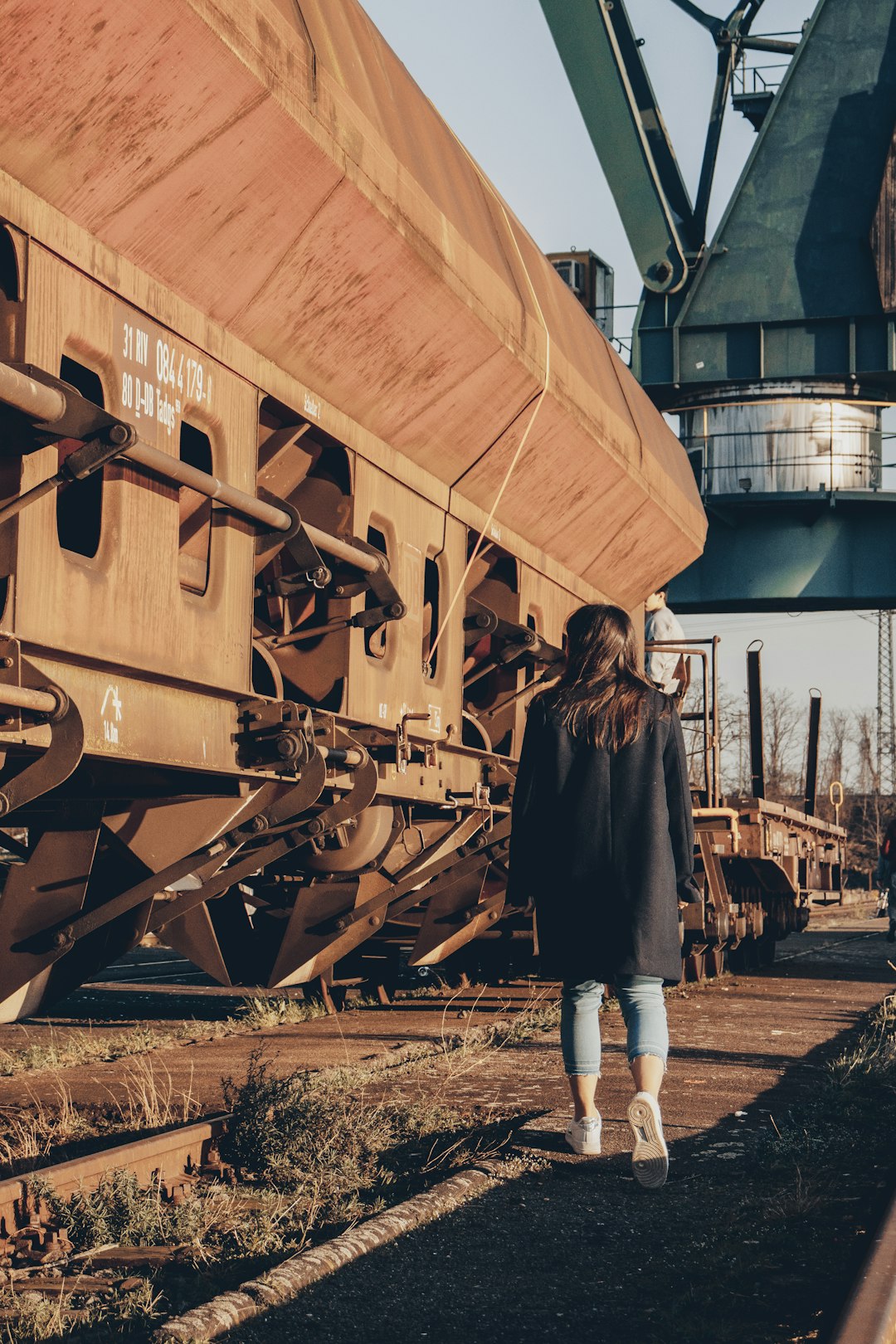 woman in black jacket standing beside brown wooden ship