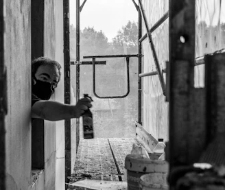 Close-up of a worker applying silicone sealant to a window frame at a construction site.