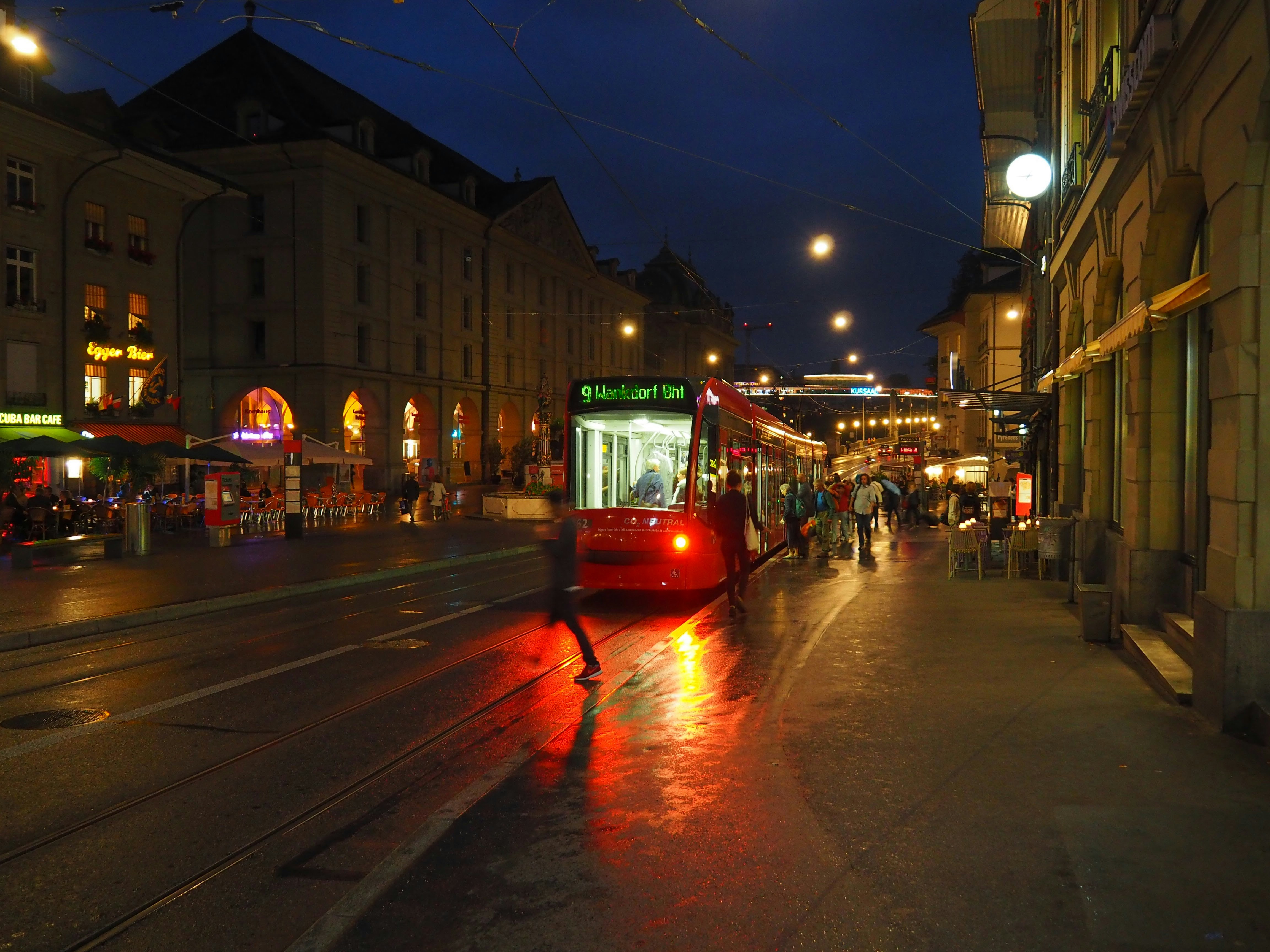 red tram on road during night time