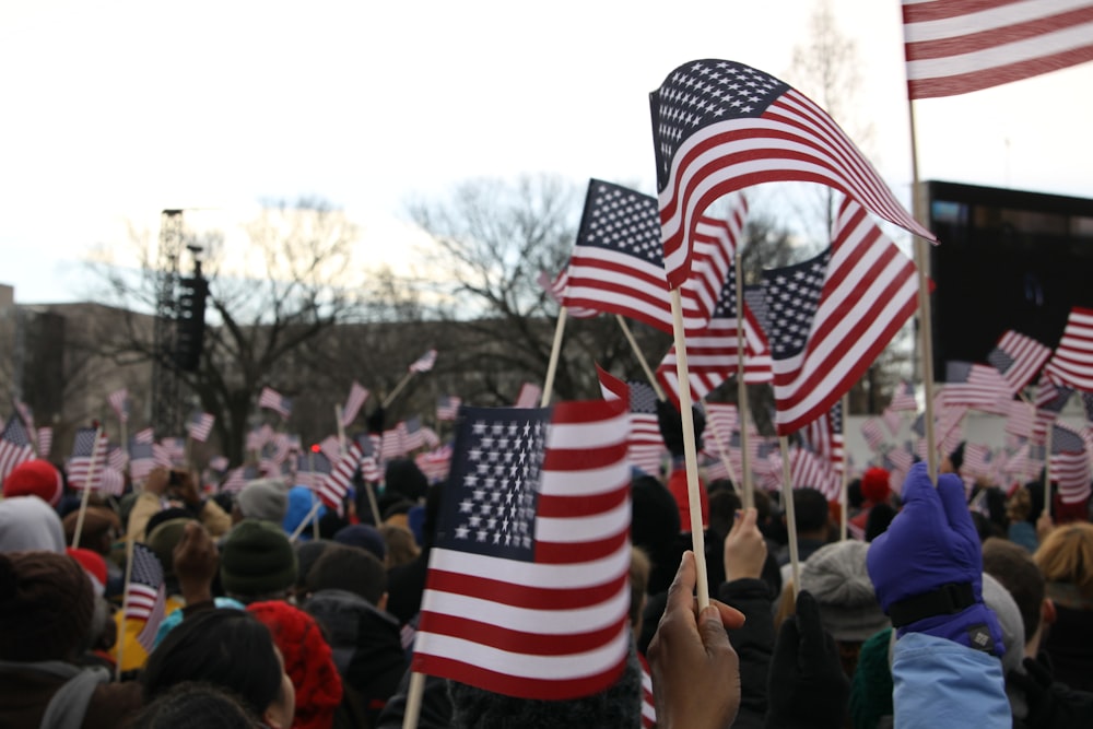 people holding us a flag during daytime