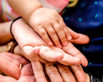 person wearing black watch holding babys hand